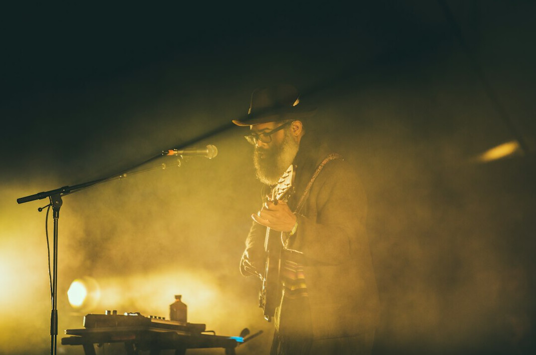 Musician performing on a stage with warm light